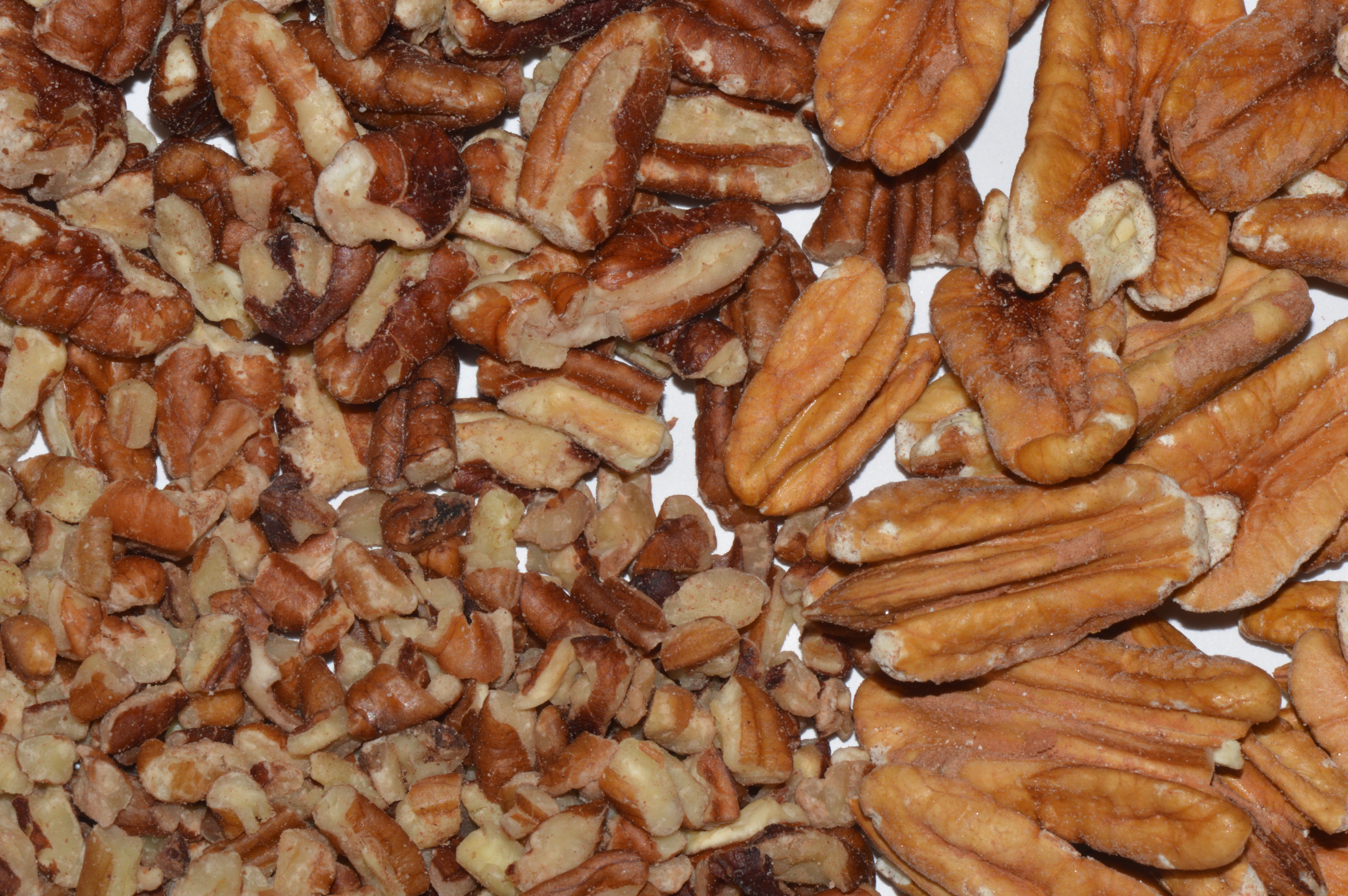 Close up shot of whole and crushed pecans.